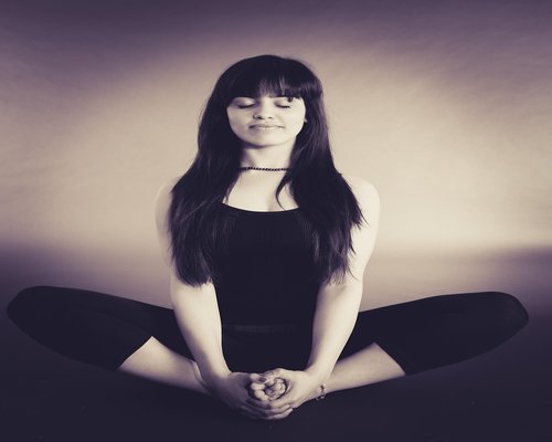 person standing comfortably doing light stretch in a well lit room